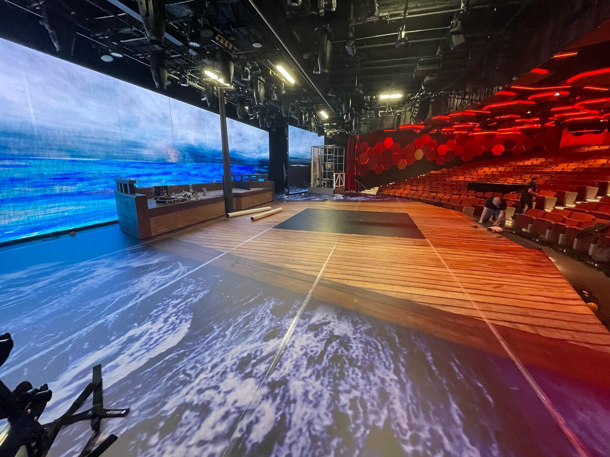 A stage covered in printed flooring like a ship.